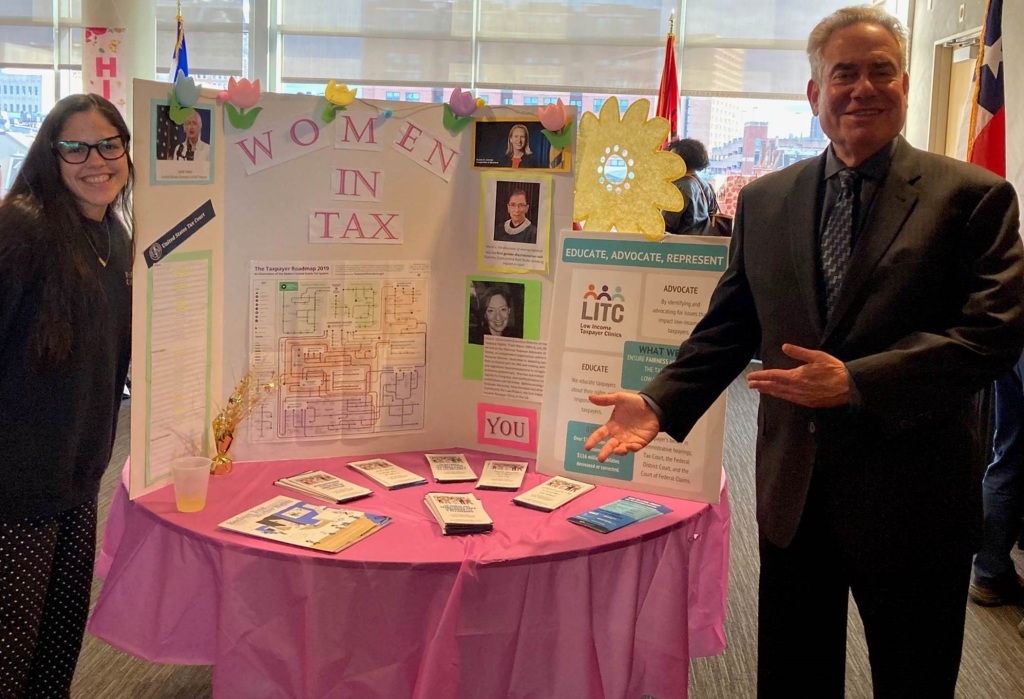 Angely Luna Martinez poses with Dean Weich in front of her Women in Tax display